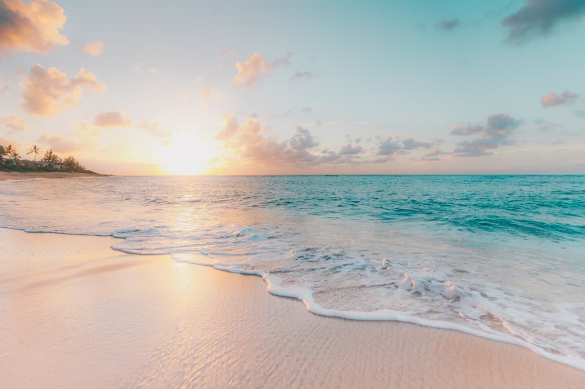 Calm shoreline at Ewa Beach on Oahu's west side with sandy patches and local park areas