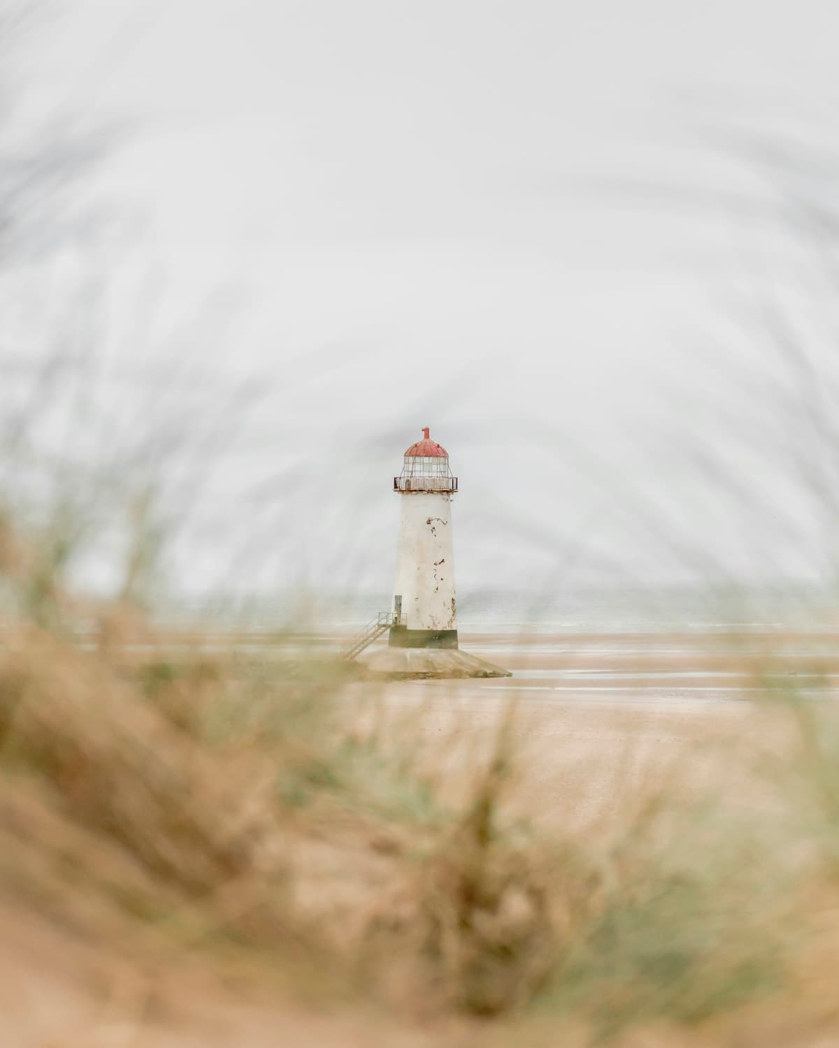 The white Point of Ayr Lighthouse standing on the wide sandy shore at Talacre Beach in North Wales